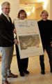 The owner of the Romantik Roewers Privathotel, Dagmar Roewers, and director Rainer Malchus accept the poster “Culture needs friends” from the chairwoman of the Theater Putbus support association, Kerstin Kassner