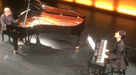 Music on keyboard and grand piano.