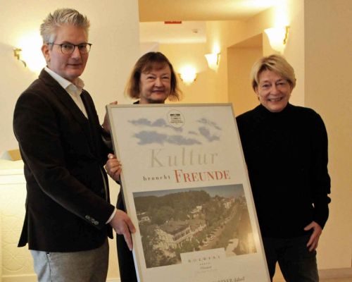 The owner of the Romantik Roewers Privathotel, Dagmar Roewers, and director Rainer Malchus accept the poster “Culture needs friends” from the chairwoman of the Theater Putbus support association, Kerstin Kassner